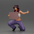 Young girl wearing a hat and pants sitting holding a sign and hitchhiking - Only-Games