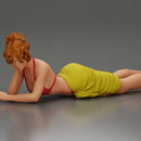 Relaxing on a beach towel, a woman enjoys sunbathing, wrapped in a pareo beach cover and bikini - Only-Games