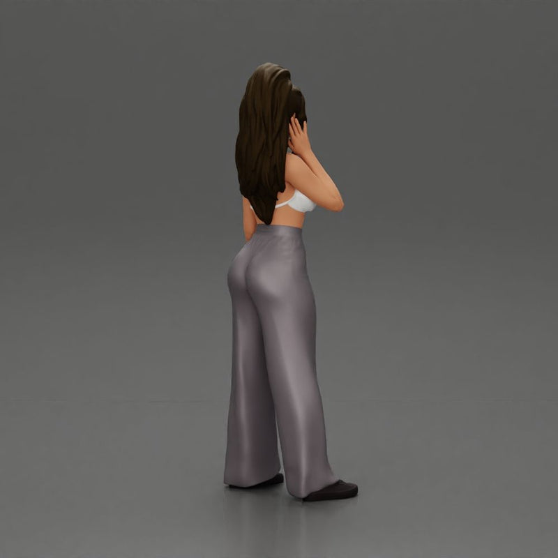 Stylish woman in a crop top and pants, standing thoughtfully