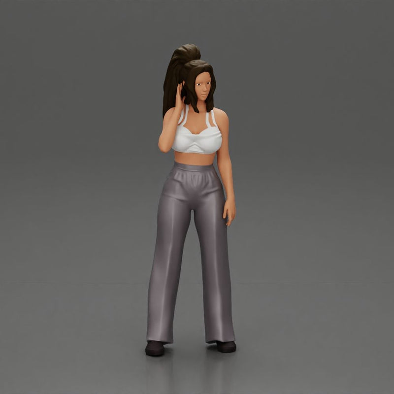 Stylish woman in a crop top and pants, standing thoughtfully