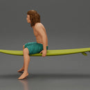 Long-Haired Surfer Sitting on a Surfboard in Calm Ocean Waters, Waiting for the Waves - Only-Games