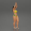 beautiful woman in a bikini with sunglasses standing with her arms raised up on the beach - Only-Games