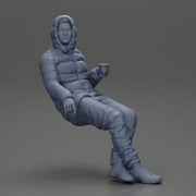 Man Sitting Wearing a Puffer Jacket, Holding a Coffee Cup - Only-Games