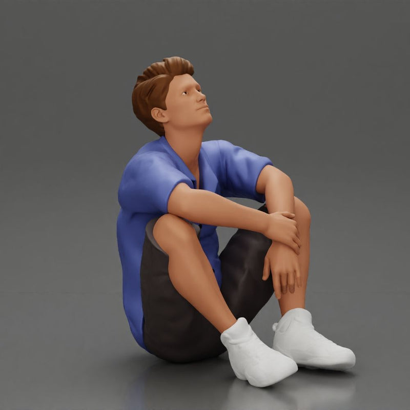 man sitting in shorts on the floor with hands on his knees - Only-Games