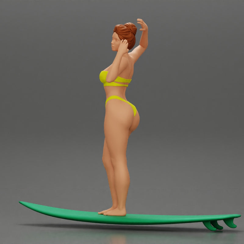 young girl posing and riding on the surfboard at the beach