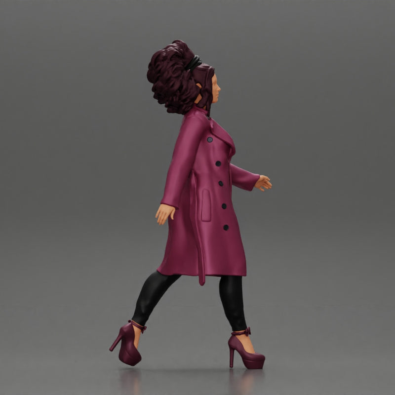 Stylish beautiful woman with curly hair in a fashion long open coat walks on the street