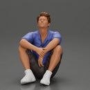 man sitting in shorts on the floor with hands on his knees - Only-Games