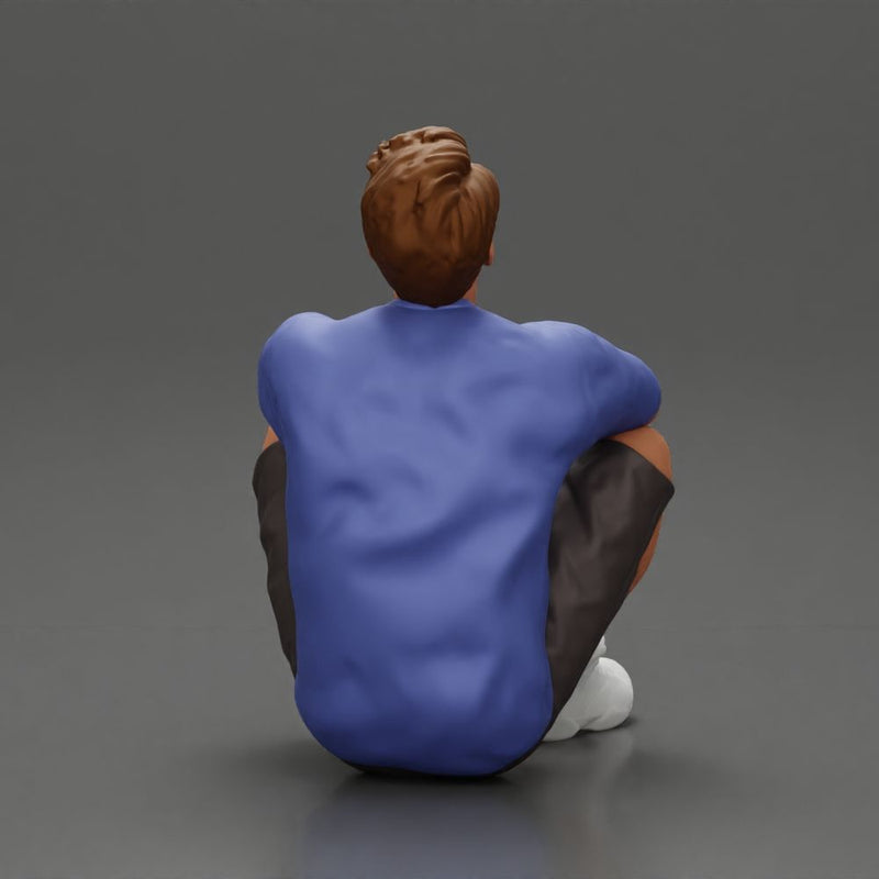 man sitting in shorts on the floor with hands on his knees - Only-Games