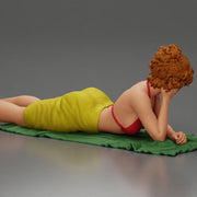 Relaxing on a beach towel, a woman enjoys sunbathing, wrapped in a pareo beach cover and bikini - Only-Games