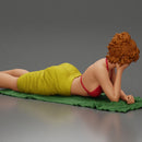 Relaxing on a beach towel, a woman enjoys sunbathing, wrapped in a pareo beach cover and bikini - Only-Games