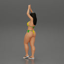 beautiful woman in a bikini with sunglasses standing with her arms raised up on the beach - Only-Games