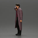 old man with pointed beard leaning against a wall in deep thought with his coat open - Only-Games