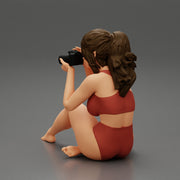 Woman photographer in bikini sitting and holding a camera - Only-Games