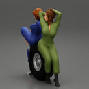 Two sexy girls in mechanic suits are sitting on a truck tire - Only-Games