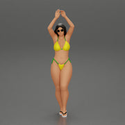 beautiful woman in a bikini with sunglasses standing with her arms raised up on the beach - Only-Games