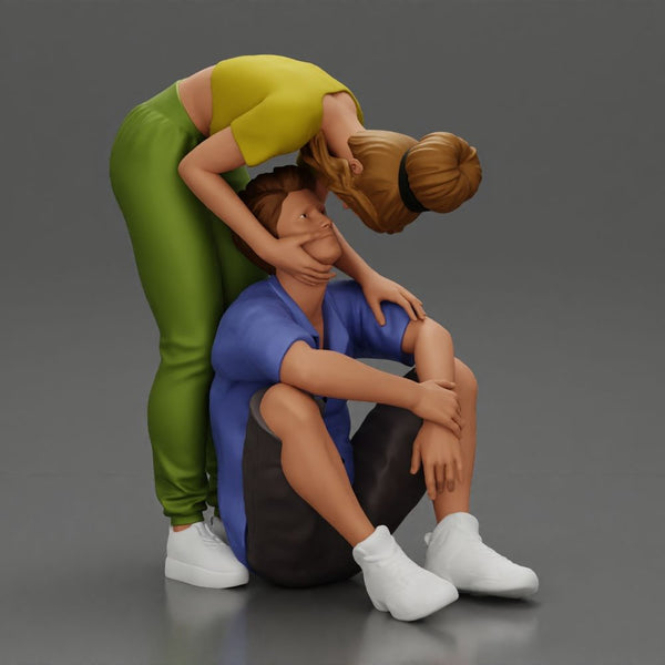 girl standing behind her boyfriend gently touching his face while he sits on the floor in shorts with his hands on his knees