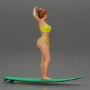 young girl posing and riding on the surfboard at the beach - Only-Games
