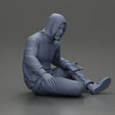 Contemplative man in hoodie sitting cross-legged, expressing curiosity thoughtfully - Only-Games
