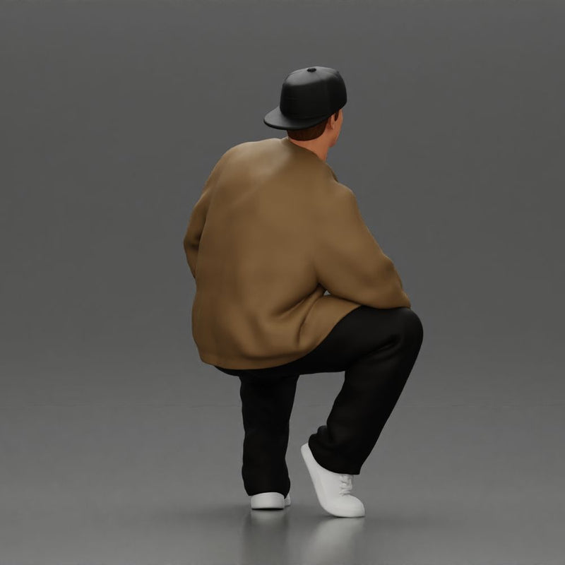 hip hop man sitting in a jacket and cap