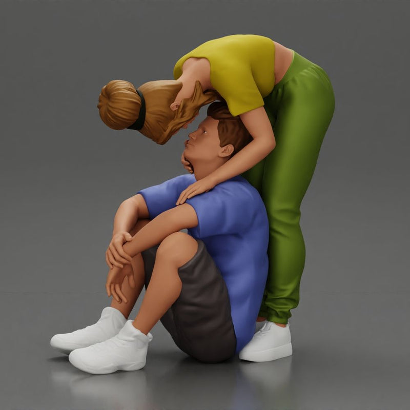 girl standing behind her boyfriend gently touching his face while he sits on the floor in shorts with his hands on his knees