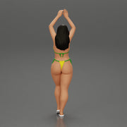 beautiful woman in a bikini with sunglasses standing with her arms raised up on the beach - Only-Games