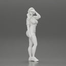 young woman in shorts and headphones shields her eyes from the sunlight - Only-Games