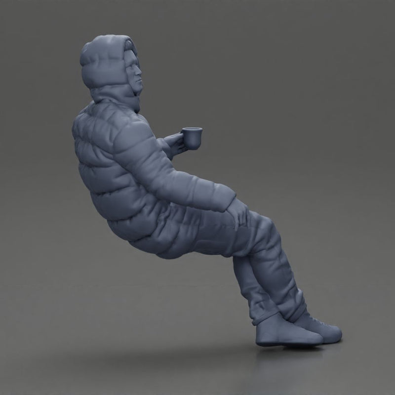 Man Sitting Wearing a Puffer Jacket, Holding a Coffee Cup - Only-Games