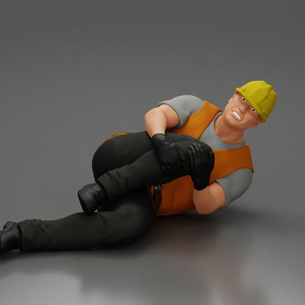 construction worker lying on the floor holding his injured leg