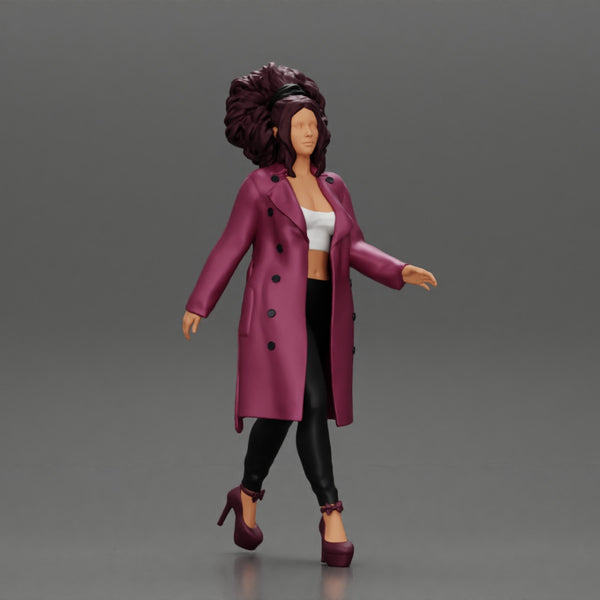 Stylish beautiful woman with curly hair in a fashion long open coat walks on the street