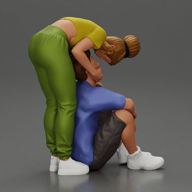 girl standing behind her boyfriend gently touching his face while he sits on the floor in shorts with his hands on his knees