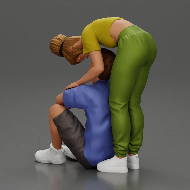 girl standing behind her boyfriend gently touching his face while he sits on the floor in shorts with his hands on his knees