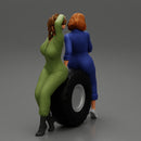 Two sexy girls in mechanic suits are sitting on a truck tire - Only-Games