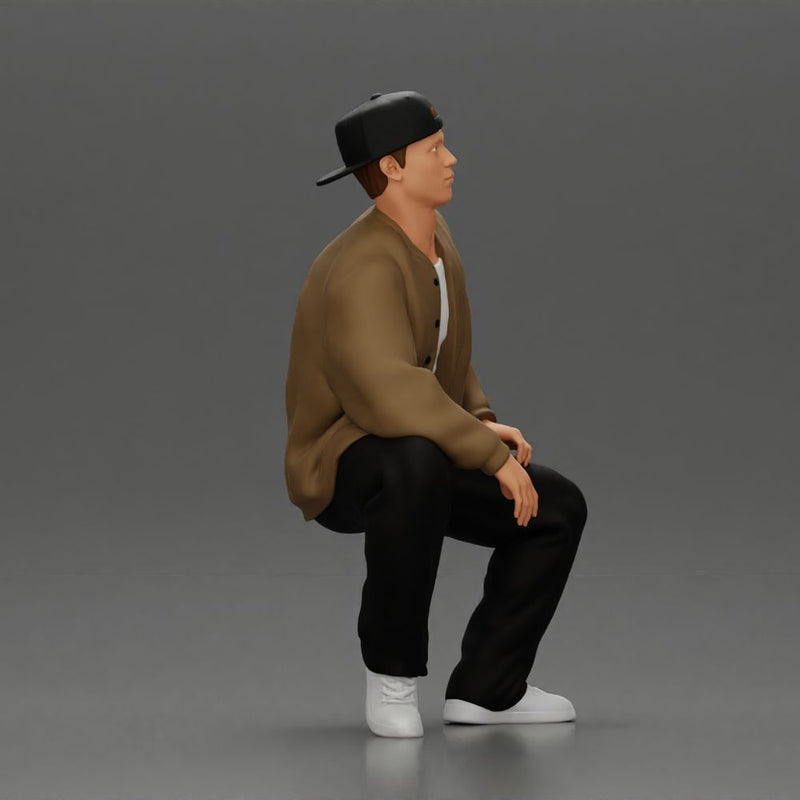 hip hop man sitting in a jacket and cap