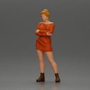 Woman in Orange Dress and Boots Stands Stylishly Confidence With Arms Crossed - Only-Games