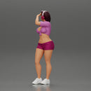 young woman in shorts and headphones shields her eyes from the sunlight - Only-Games