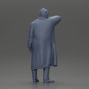 old man with pointed beard leaning against a wall in deep thought with his coat open - Only-Games