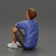 man sitting in shorts on the floor with hands on his knees - Only-Games