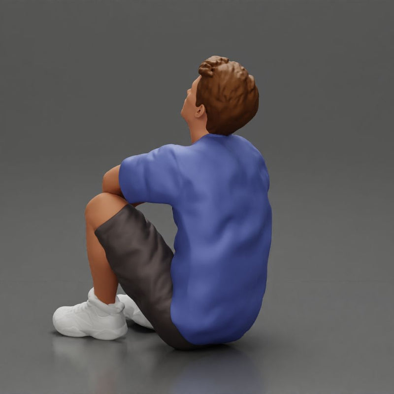 man sitting in shorts on the floor with hands on his knees