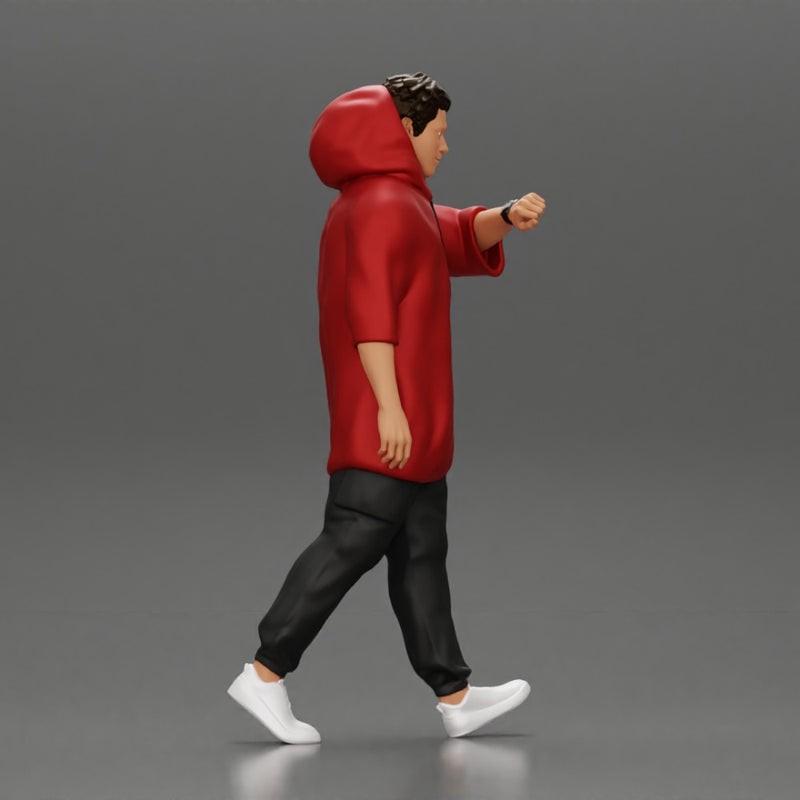 Man in a long hoodie  walking and looking at his watch