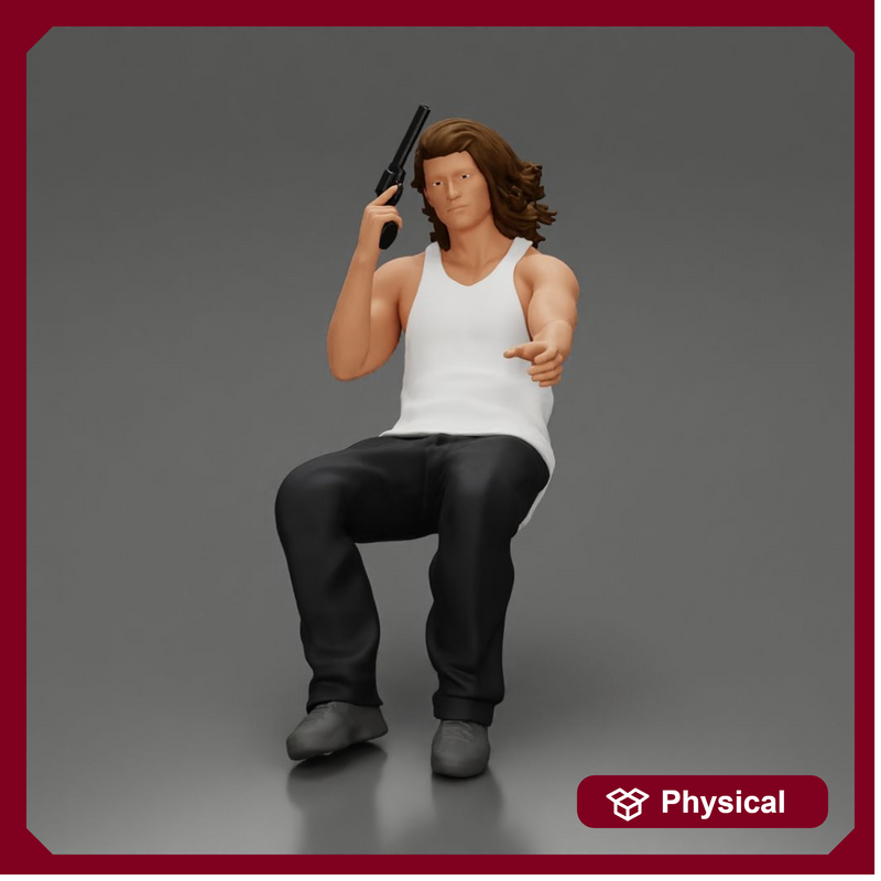 Man sitting with gun in hand pointing forward calmly