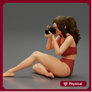 Woman photographer in bikini sitting and holding a camera