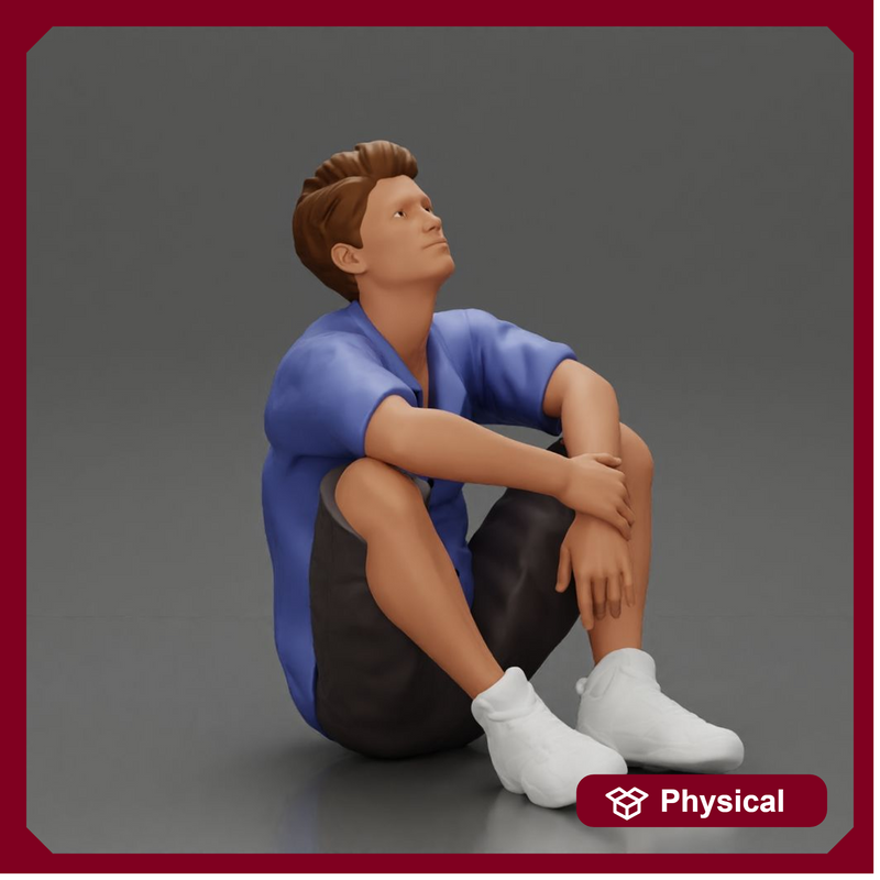 man sitting in shorts on the floor with hands on his knees - Only-Games