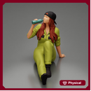 Tired woman mechanic in suit and backwards cap sitting and drinking water during from bottle